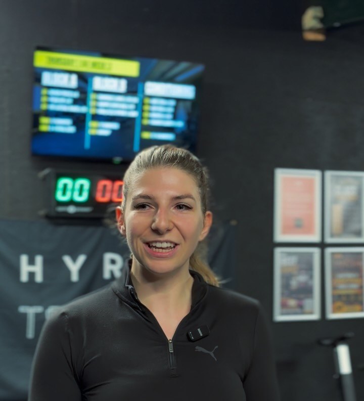 A LIFT coach in the Portlaoise studio in front of the HYROX wall and workout screens